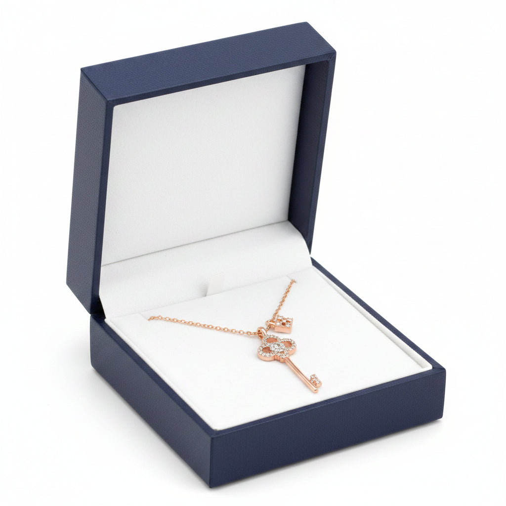 Rose gold key-shaped pendant necklace on a white background