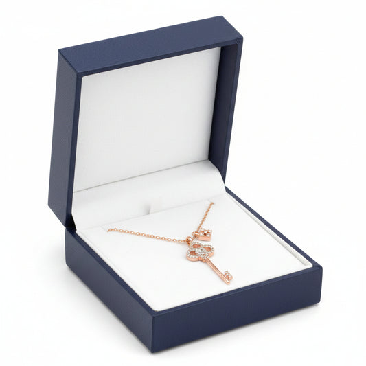 Rose gold key-shaped pendant necklace on a white background