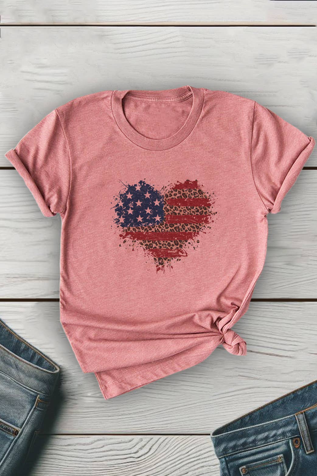 Pink t-shirt with a heart-shaped American flag design on a wooden surface