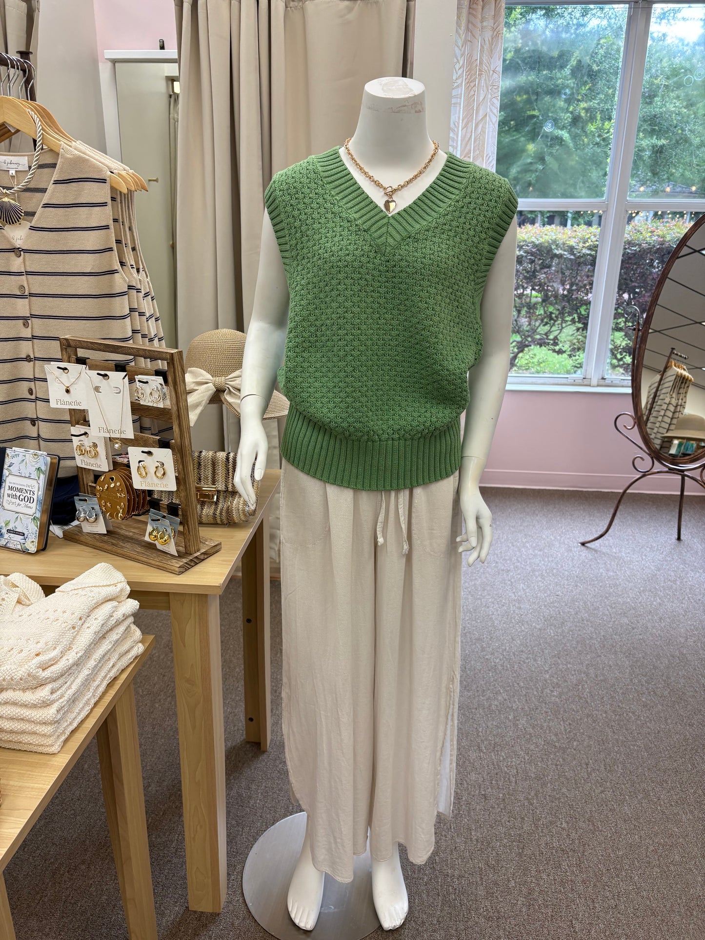 Green V Neck sweater on a display form wearing beige pants