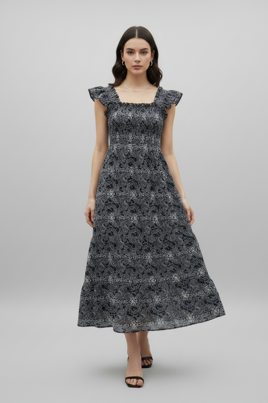 Woman wearing a navy floral dress on a gray background