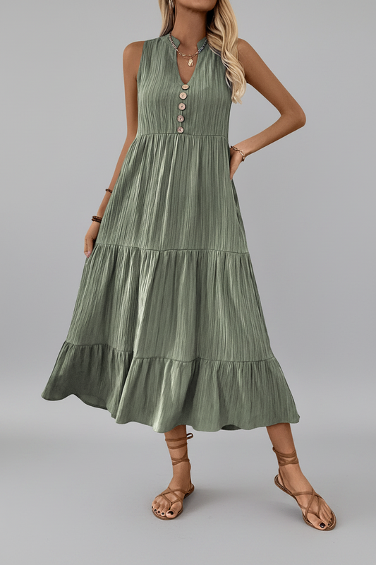 Woman wearing a green dress with buttons on a gray background