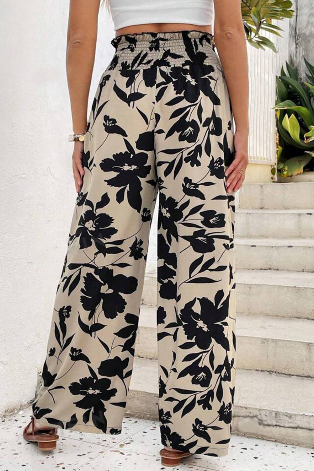 Person wearing black floral pants with a white background