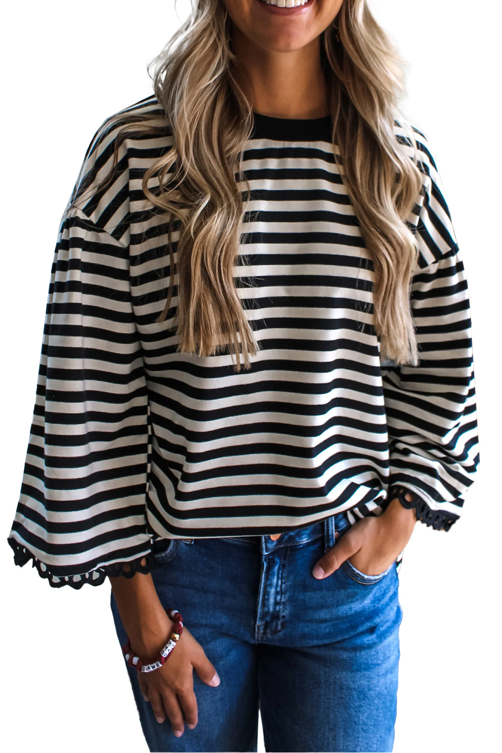 Woman wearing a black and white striped shirt with long sleeves and blue jeans.