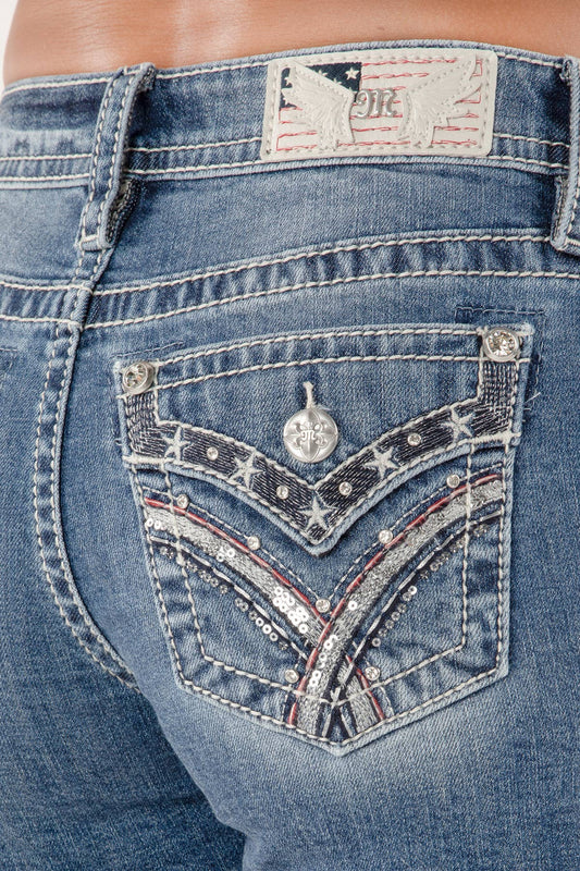 Close-up of blue jeans with decorative pocket and brand logo.