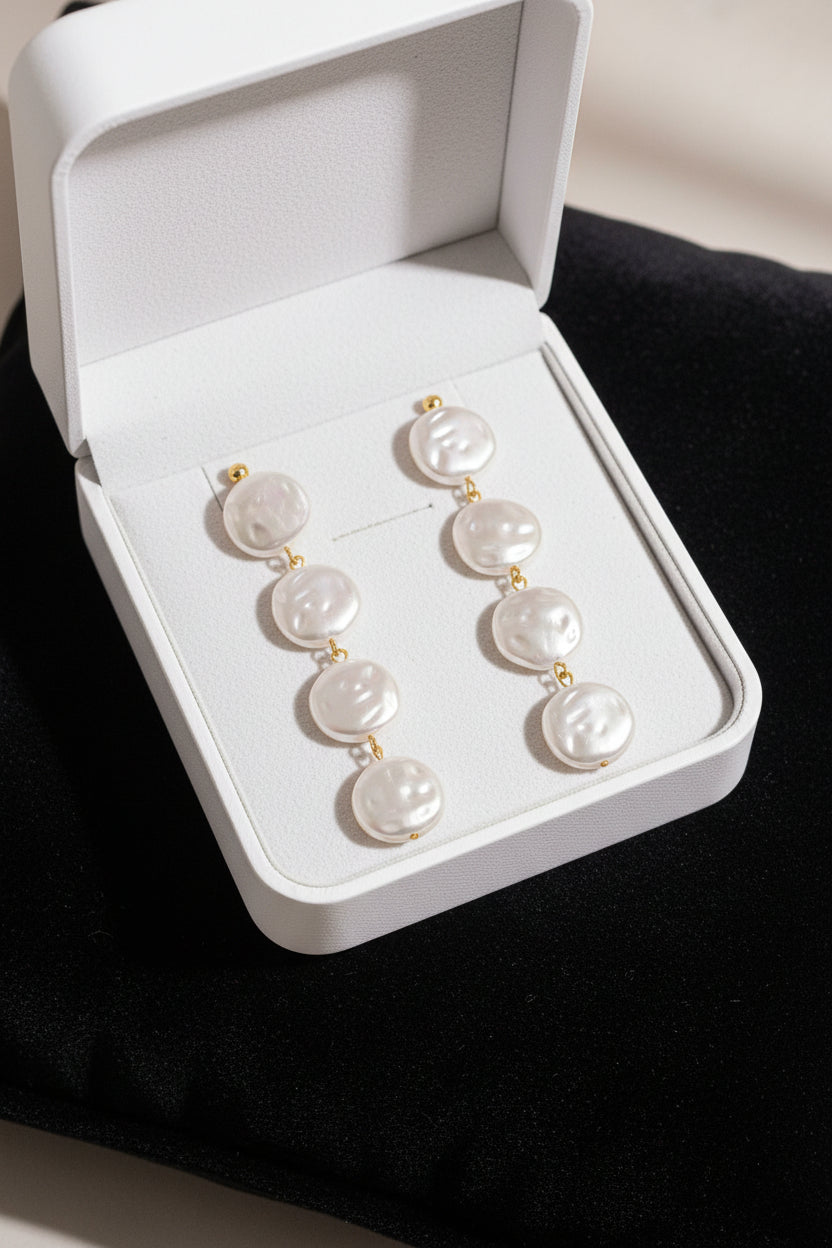 White circular earrings on an orange surface