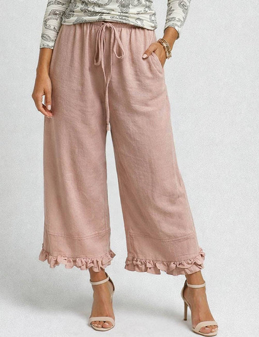 Pink wide-leg pants with ruffled hem worn by a person on a white background