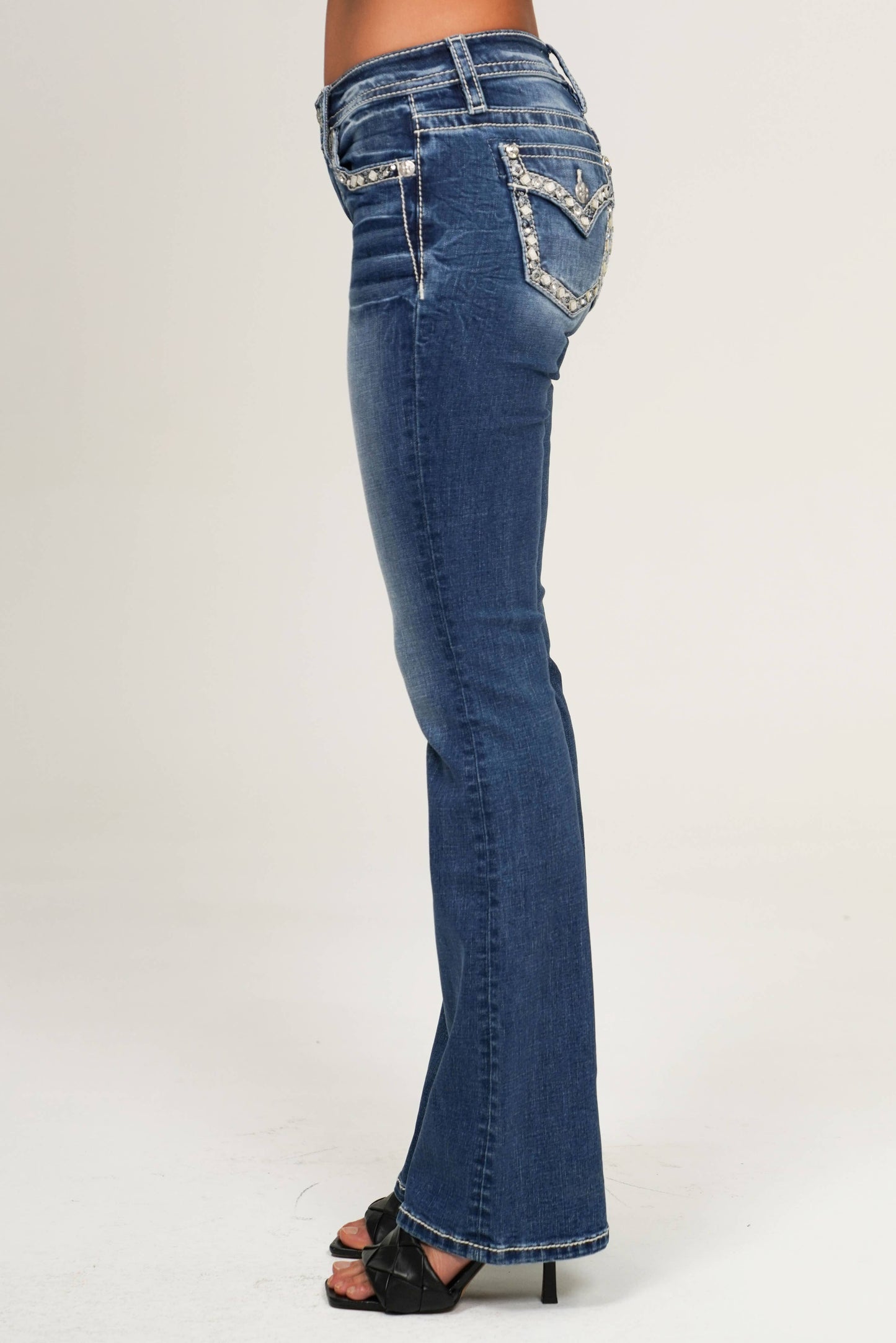 Blue jeans with embellishments on a white background
