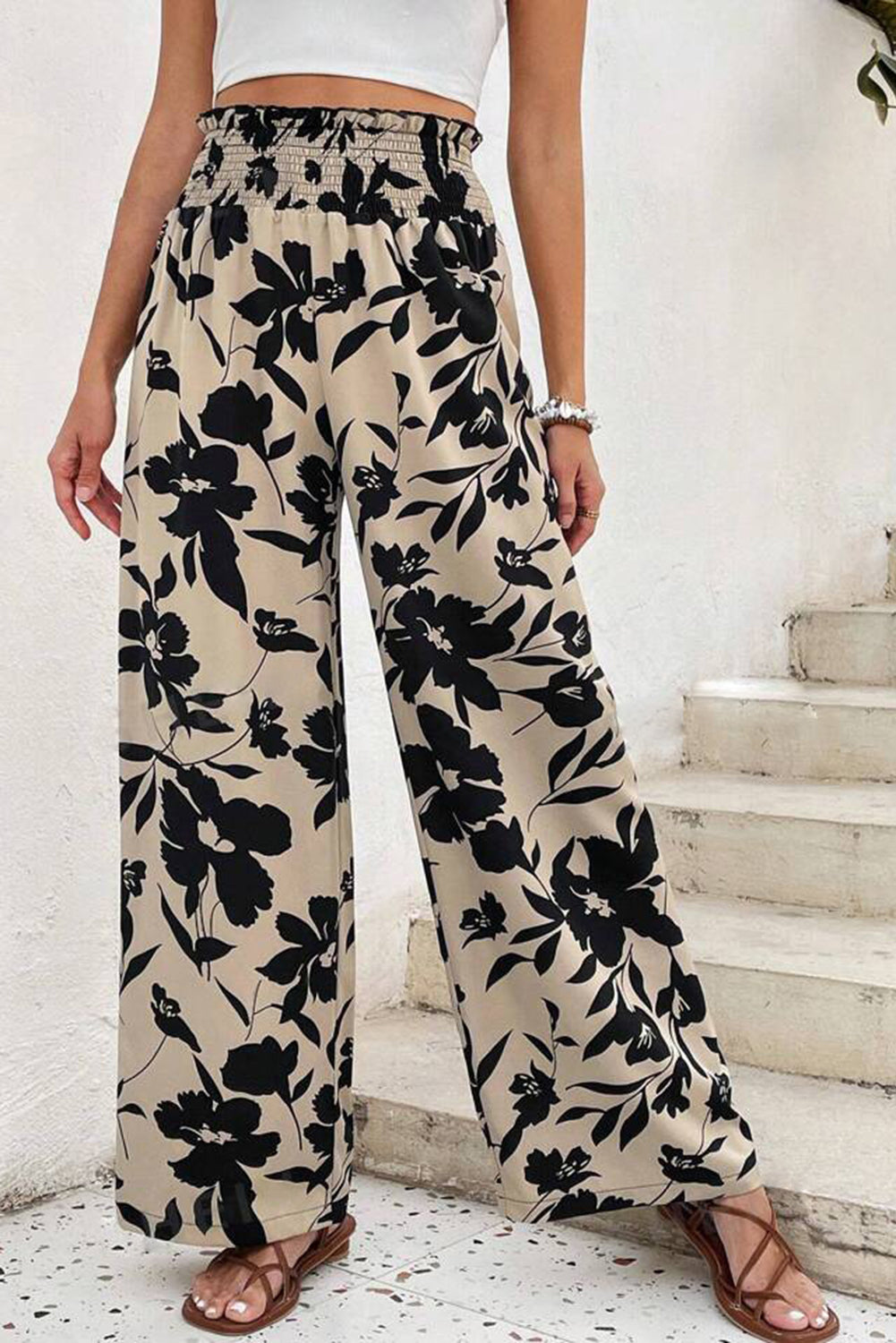 Person wearing black floral pants with a white background