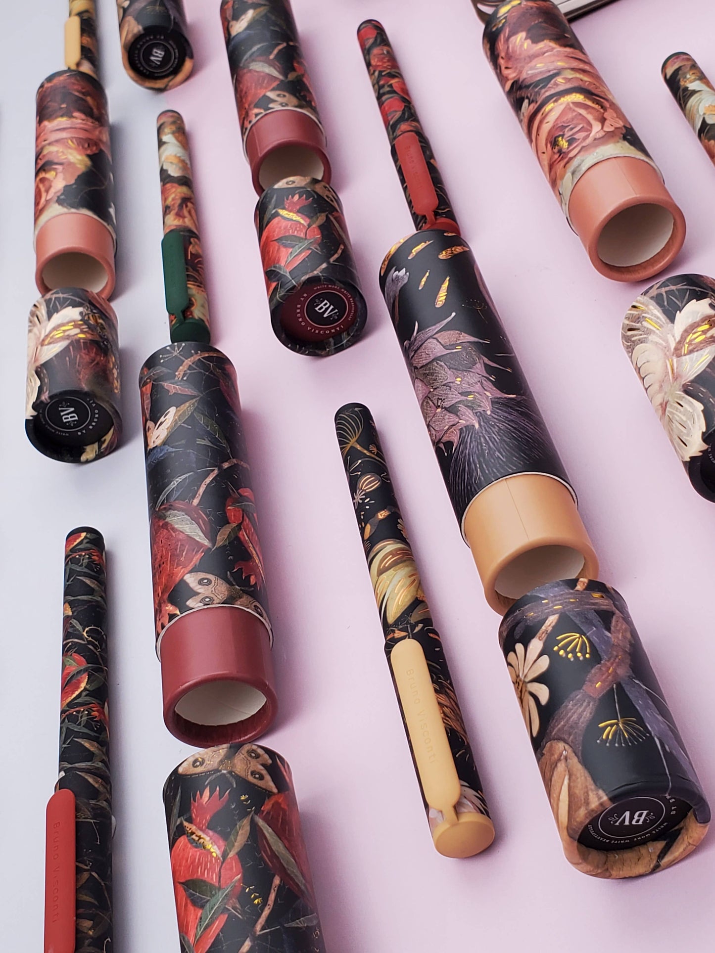 Decorative paper rolls with floral patterns on a light pink background