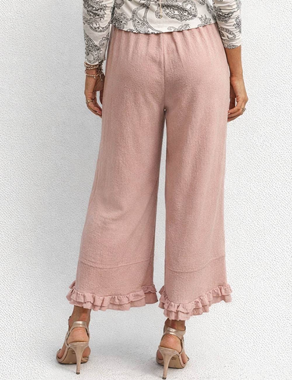 Pink ruffled pants worn by a person on a white background