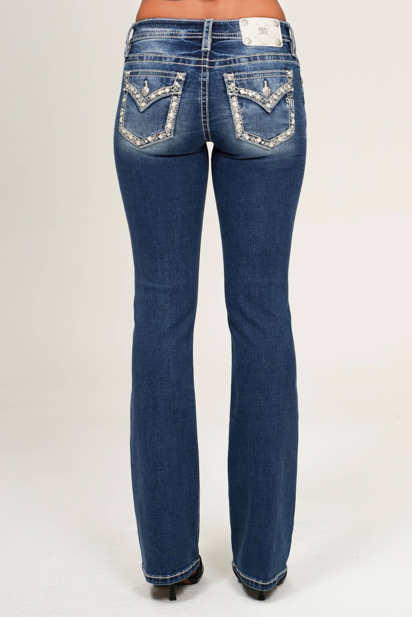 Blue jeans with decorative stitching on a white background