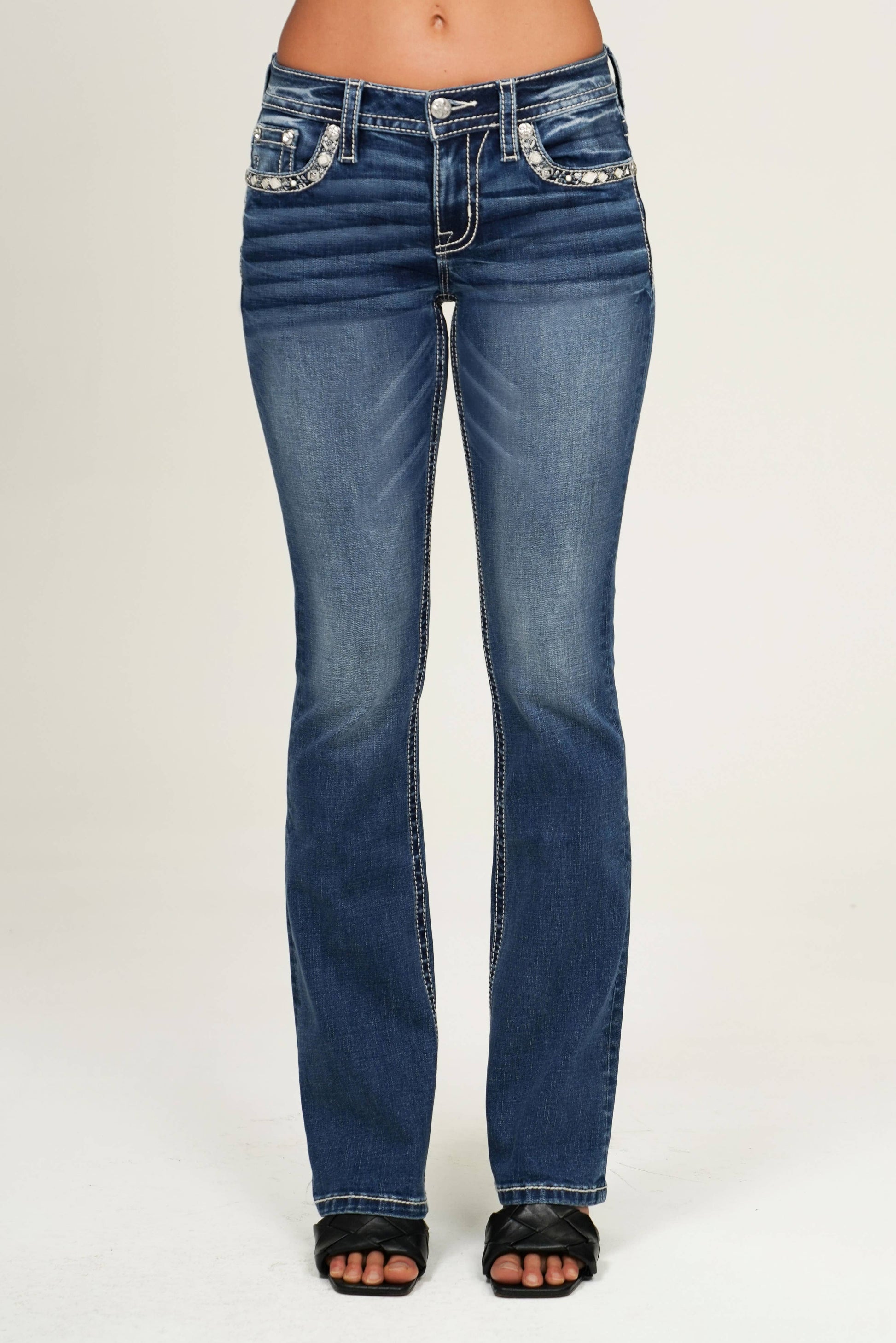 Blue jeans with embellishments on a white background