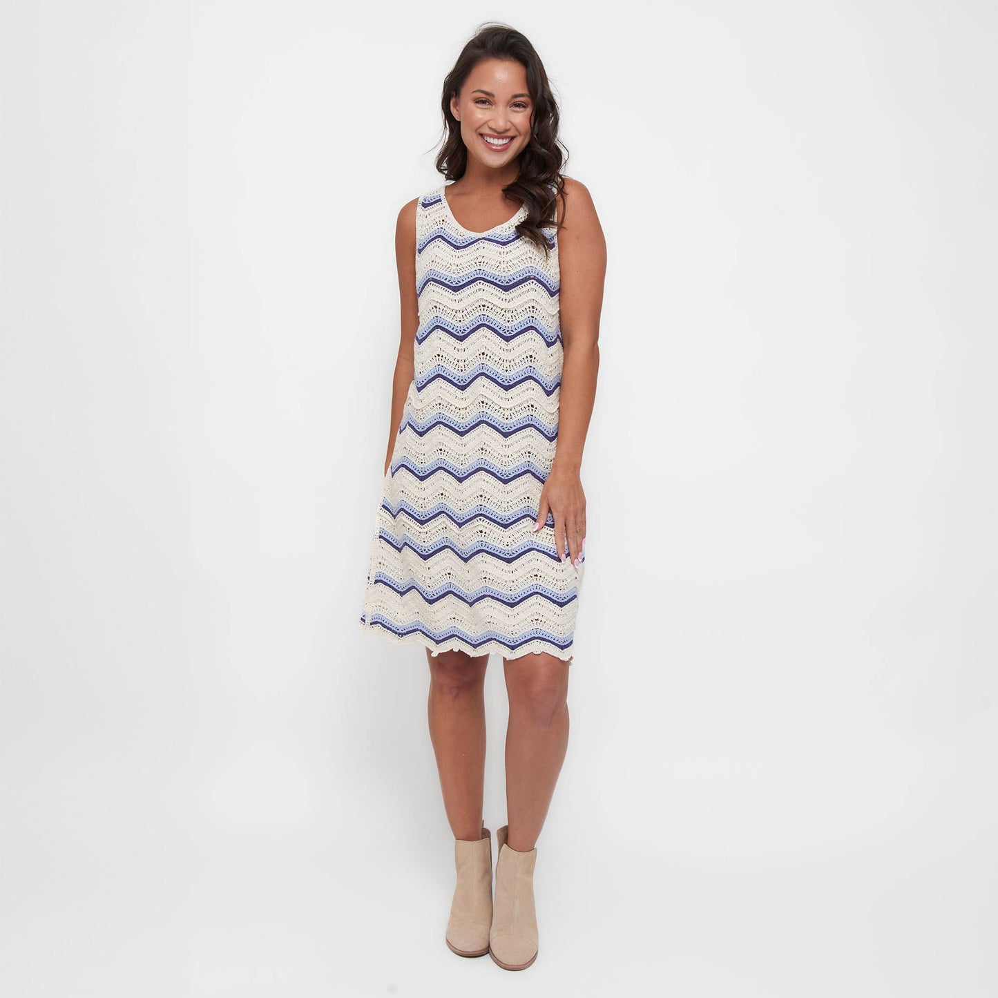 Woman wearing a sleeveless dress with a zigzag pattern on a white background
