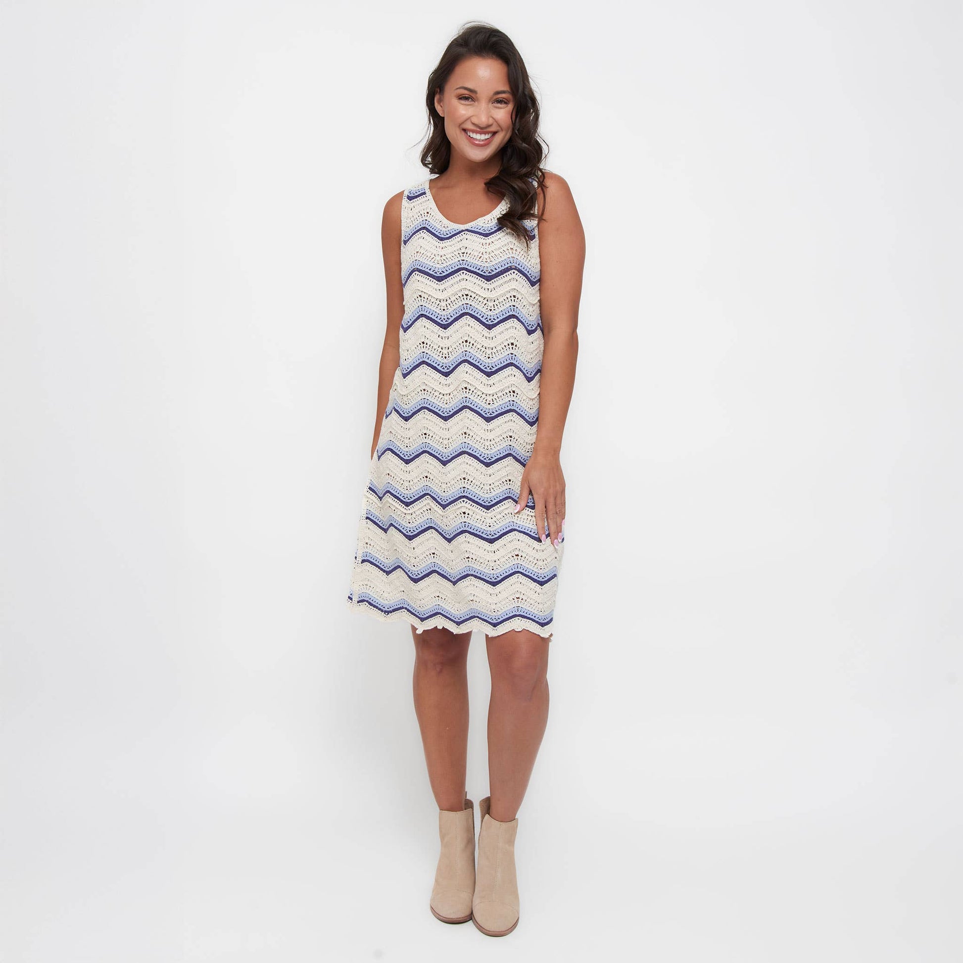 Woman wearing a sleeveless dress with a zigzag pattern on a white background