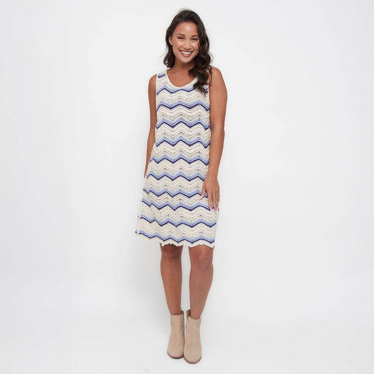 Woman wearing a sleeveless dress with a zigzag pattern on a white background