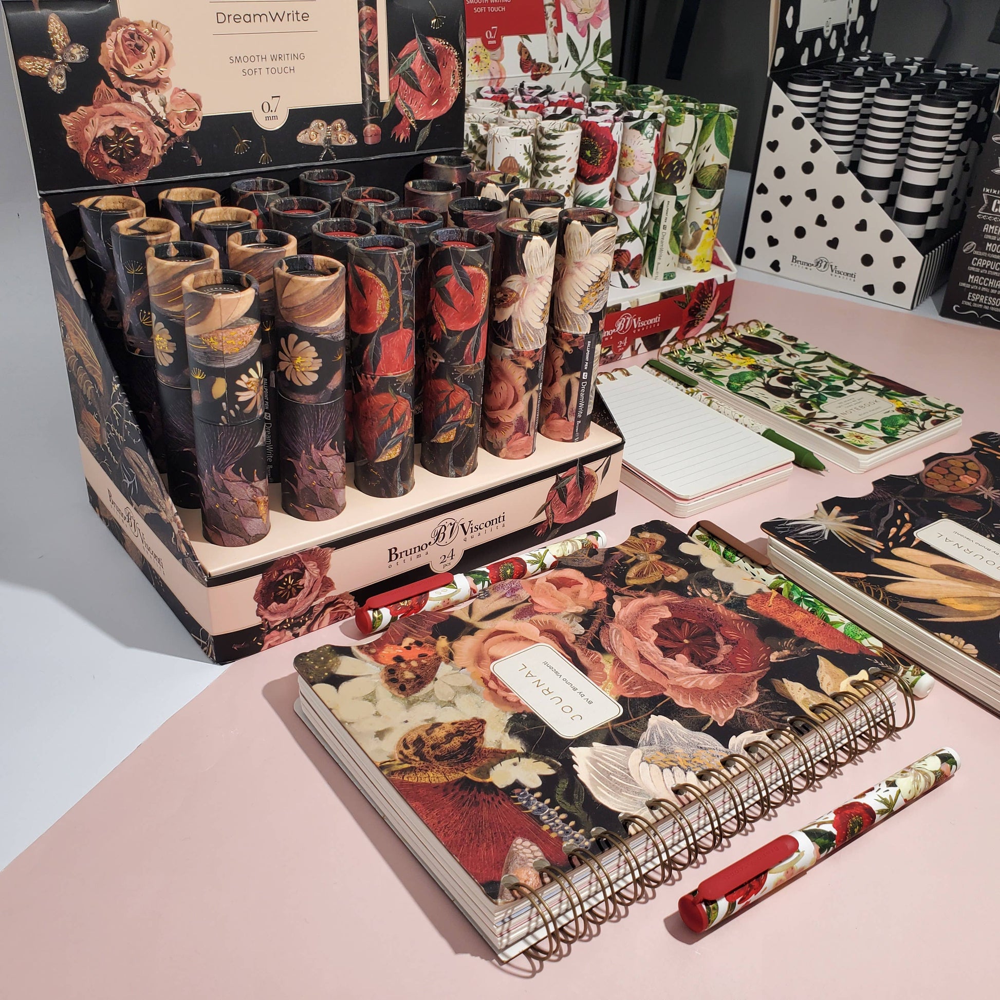 Decorative notebooks and stationery items on a display table with floral designs.